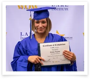 female graduate wearing blue cap and gown and holding their certificate